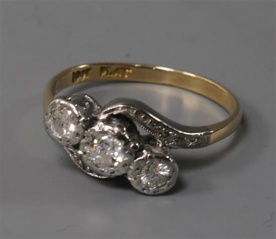 An 18ct gold and platinum, three stone diamond crossover ring, size N.